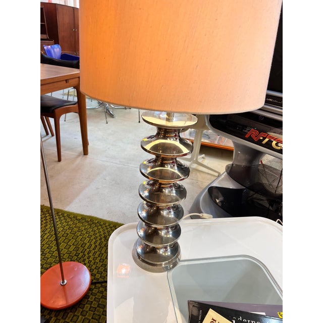 Futuristic Space Age design meets classic elegance here. The striking frame of this table lamp captivates with its dynamic...