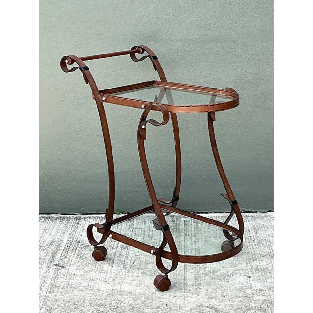 This elegant vintage bar cart, crafted in the style of Hermès, showcases a sophisticated combination of glass and metal...