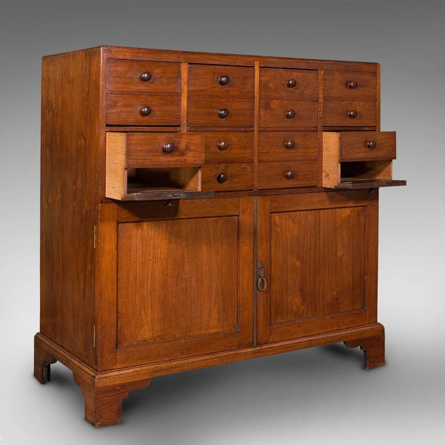 This is a large antique butler's cabinet. An English, walnut and oak estate chest of drawers, dating to the early...