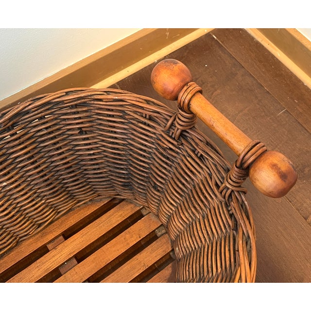 Charming vintage woven wicker basket featuring beautifully turned wood handles and a sturdy solid wood slatted base. The...