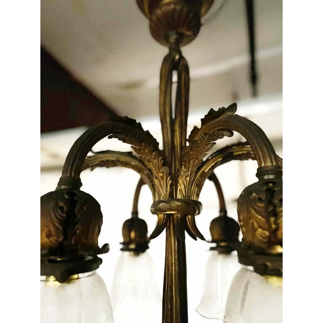 Antique French bronze five light chandelier. This elegant chandelier has frosted and etched tulip form shades with floral...