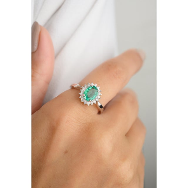 Discover elegance with our 18K white gold oval cut emerald halo diamond ring. This stunning piece features a vibrant...