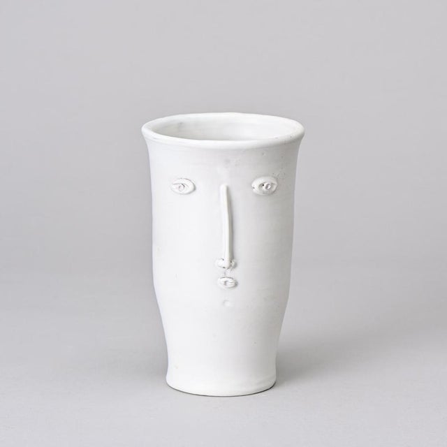 Face vase designed by Robert and Jean Cloutier in the 1960s. It is made of red ceramic with white glaze, conical in shape,...