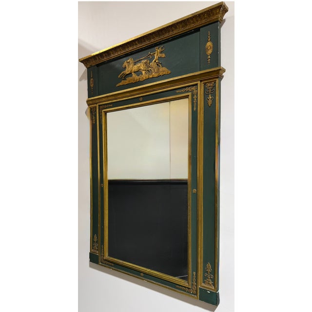 Early 19th century carved French Empire trumeau style mirror. Features a depiction of a chariot and horses on the main...