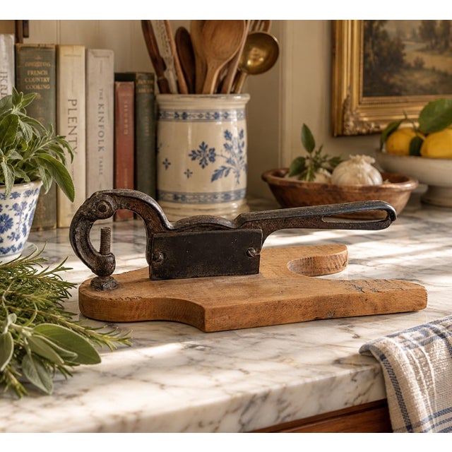 A beautifully timeworn antique wooden herb cutter with forged iron blade and handle, dating to the early 20th century....