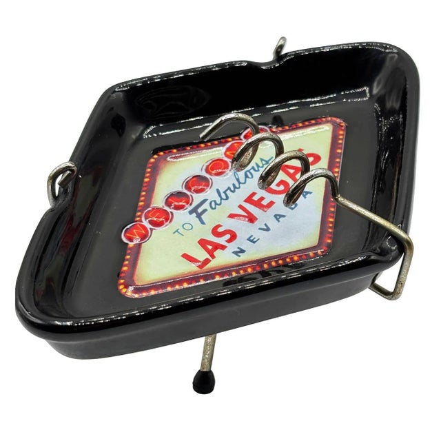 This stylish mid-century-inspired black ceramic ashtray features the iconic "Welcome to Fabulous Las Vegas" sign in a...