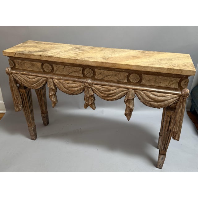 Neoclassical carved and painted Italian console table. The top is Faux painted to look like marble, and the front is...