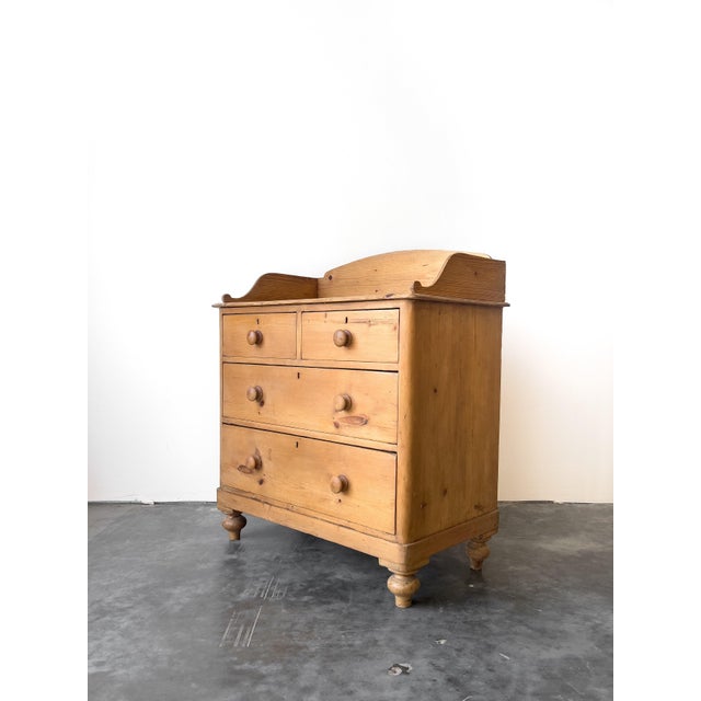 A charming antique English pine chest of drawers with gallery back. Two over two drawer configuration, solid drawer bases...