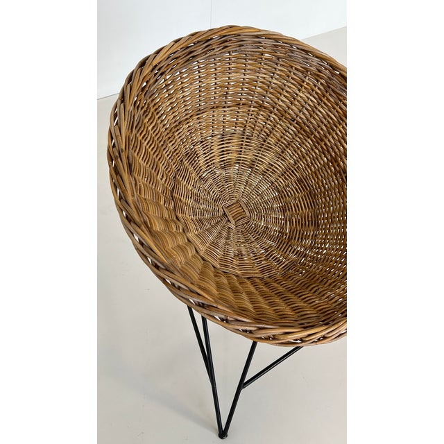 A prized design classic. Comfortable wicker armchair, cone-shaped and woven from willow, with an elegantly curved, black...
