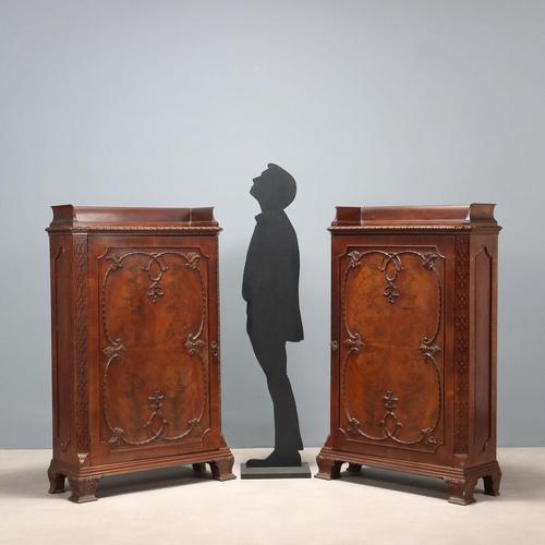 Pair of mahogany cupboards. Central paneled door, mirrored mahogany crotchet enriched with leaf carvings, scrolls, and...