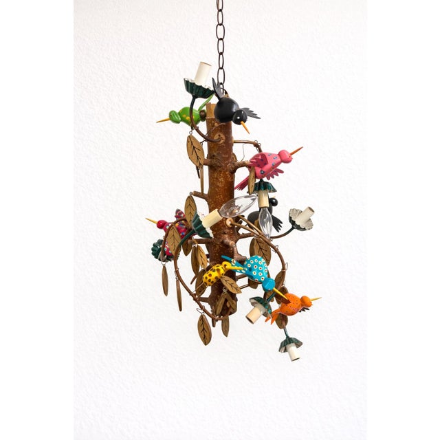 Vintage handcrafted folk-art chandelier with colorful hand-painted hummingbirds mounted on a natural wood branch...