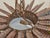 A dramatic Spanish Midcentury sunburst light fixture, crafted in gilt hammered metal with striking sculptural presence....