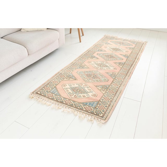 This is a vintage Turkish Oushak rug from the Mid 20th Century. The piece was hand-knotted.