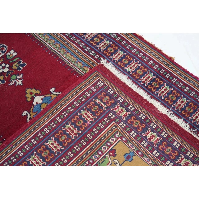 In a general Ghiordes Turkish style with a red lobed niche supported by side colonettes, suspending a mosque lamp from the...