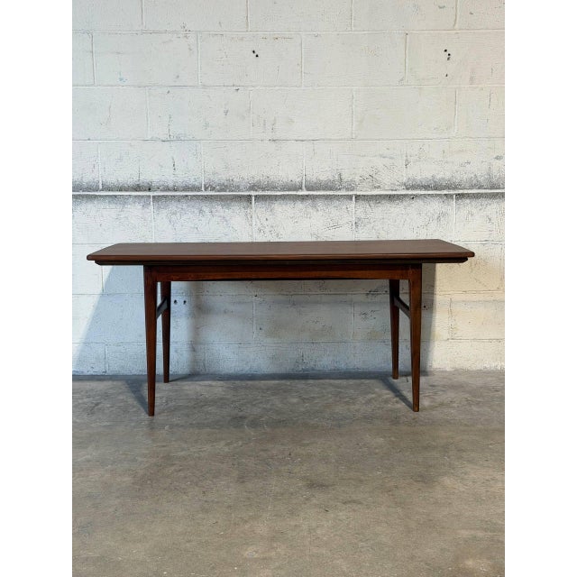 This rectangular coffee table features an extendable design with two pull-out leaves. Its clean lines and tapered legs...