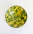 An antique 19th century earthenware bowl with hand-painted yellow and green freeform brushwork. Crafted from a warm...