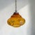 Vintage amber glass pendant light with a distinctive organic silhouette and delicate floral decoration. The shade is made...