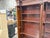 Elegant vintage cherry wood bookcase featuring a beautifully crafted classical design with decorative columns, carved...