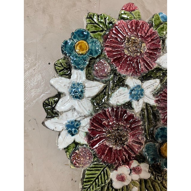 Ceramic wall decoration depicting a vibrant bouquet of flowers.