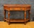 Spanish console table dating to the early 20th century. The piece features a shaped top with a small raised back, a...