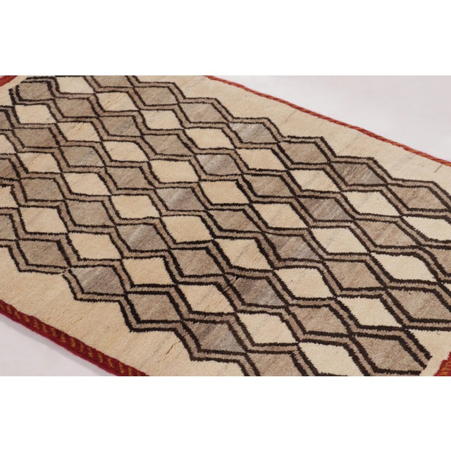 Hand-knotted in wool circa 1950–1960, this 3x4 vintage Persian Gabbeh rug is a charming example of tribal minimalism...