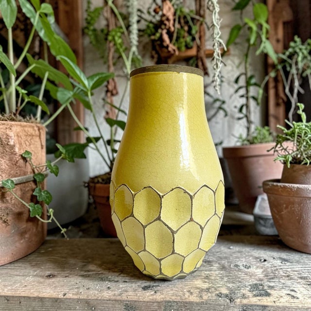 This piece features a distinctive yellow crackle glaze body, a contrasting dark unglazed clay rim, and a raised,...