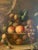 Large and impressive “reach-out-and-touch-it” basket of fruit with silver goblet reproduction print by American artist...