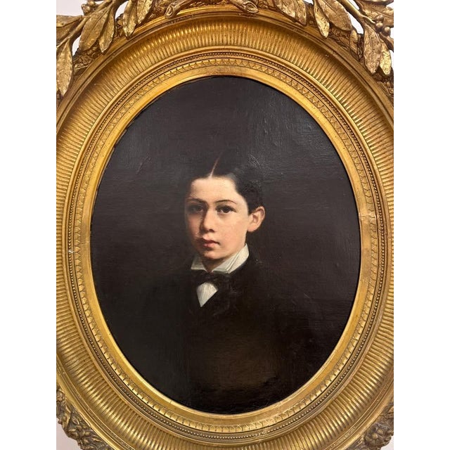 Charming 19th-century oil-on-canvas portrait depicting a young boy dressed in formal attire, rendered with a particularly...