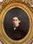 Charming 19th-century oil-on-canvas portrait depicting a young boy dressed in formal attire, rendered with a particularly...