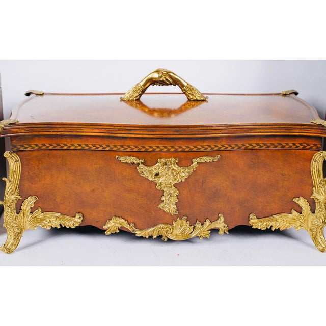 An exceptional Maitland-Smith burl wood casket-form box, richly mounted with ornate gilt bronze and crowned with a...