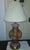 Transparent pink glass ginger jar lamp with handpainted white and gold lilies. Interior orange-y column, with tarnished...