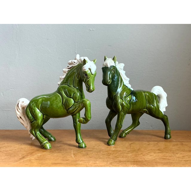 This pair of ceramic horses captures spirited, dynamic movement through confident equine posturing, one figure standing...