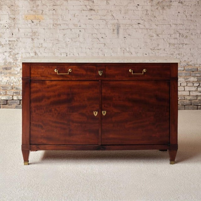 A late 19th-century French Directoire-style commode crafted from richly grained cherry wood, showcasing a warm, lustrous...