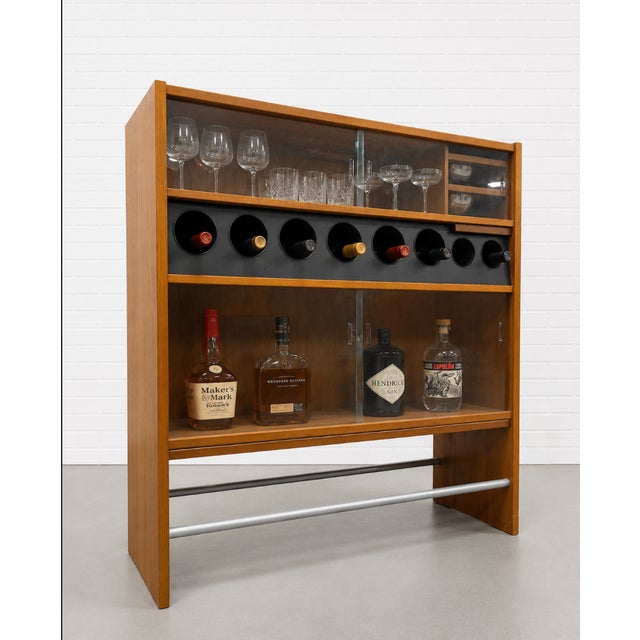 Danish Mid Century Modern Teak Dry Bar designed by Poul Heltborg, c. 1960s. The design features two sliding glass doors...