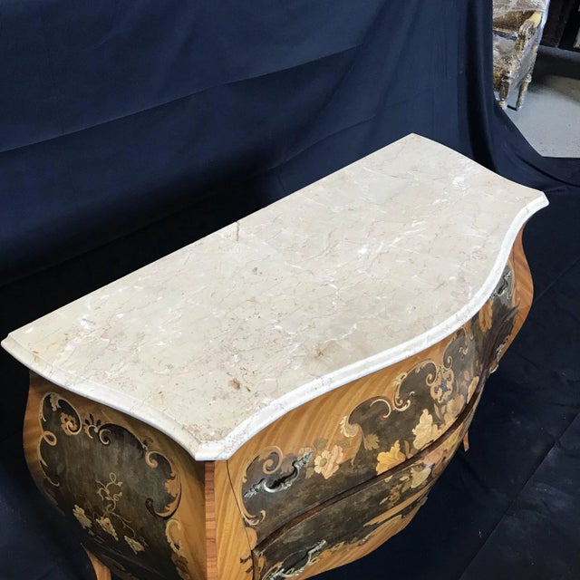 A particularly beautiful French Louis XVI bombe commode with intricate mixed wood marquetry in walnut and fruitwoods. Top...