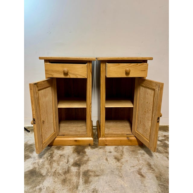 This pair of early 20th-century European pine pot cupboard nightstands features a clean, simple design paired with sturdy,...