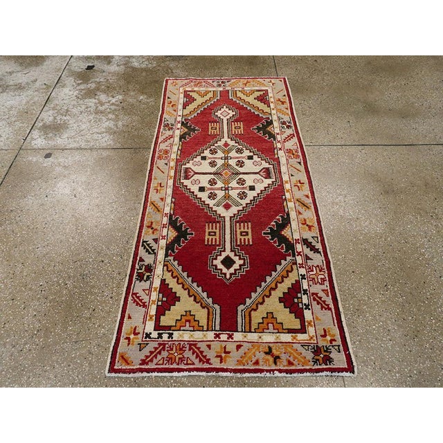 This vintage Turkish Oushak throw rug has a Caucasian air with its rich red field and stepped, medallion with equally...