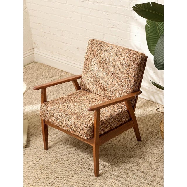 A handsome vintage armchair with a warm walnut frame and a classic mid-century silhouette. The clean, gently tapered legs...