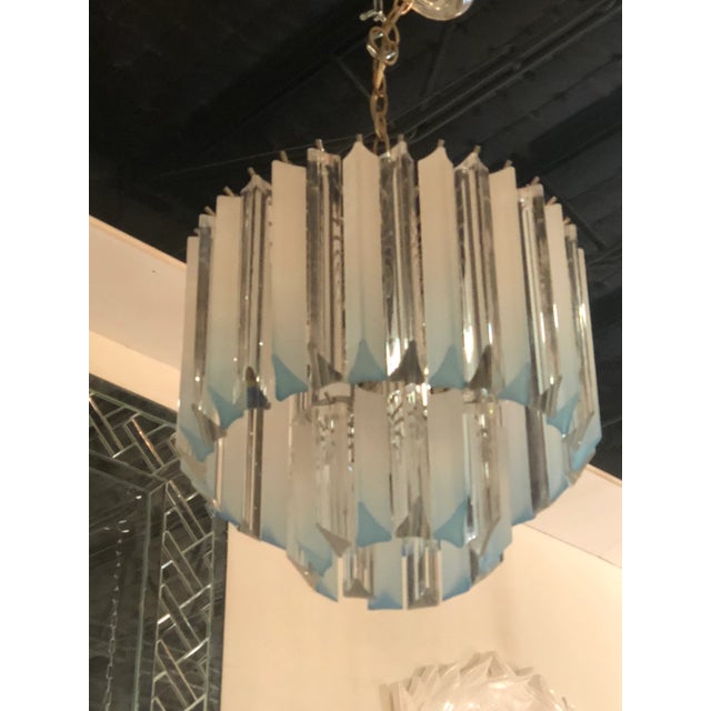 Vintage aqua blue Lucite, two-tier chandelier with chrome cage and ceiling canopy. Chrome cage may have tarnishing. Holds...