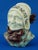 Item description: a stunning sculpture depicting the bust of an elderly woman wearing a bonnet decorated with incised...