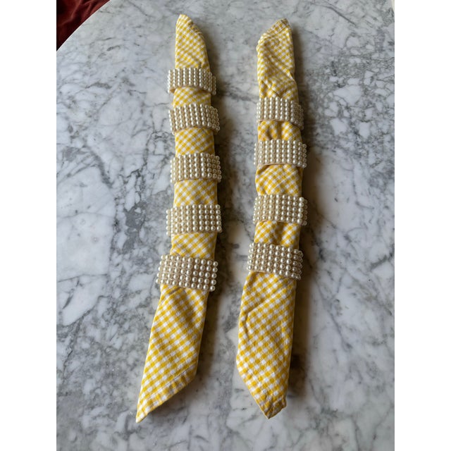 Set of nine midcentury faux pearl napkin rings. Each of the nine napkin rings have 95 pearls (19 by 5 rows) attached to a...