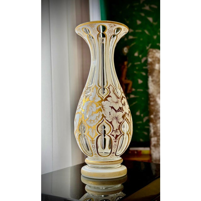 A finely crafted 19th century Bohemian art glass vase with white overlay and hand-applied gilt decoration. The piece...