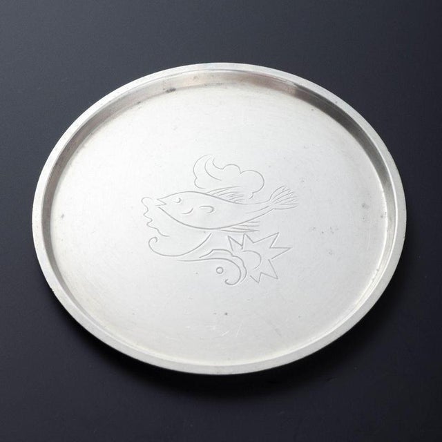 Set of seven pewter bottle coasters, engraved with animal motifs – including lion, snake, and birds. Classic round form...