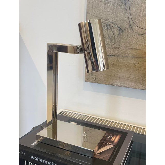 A sleek vintage desk lamp with a distinctly modernist, late-20th-century aesthetic. Executed entirely in polished chrome,...