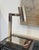 A sleek vintage desk lamp with a distinctly modernist, late-20th-century aesthetic. Executed entirely in polished chrome,...