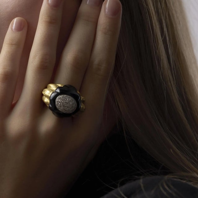 This bold vintage Maz ring pairs striking onyx with sparkling diamonds in rich 18k yellow gold, reflecting the sculptural...