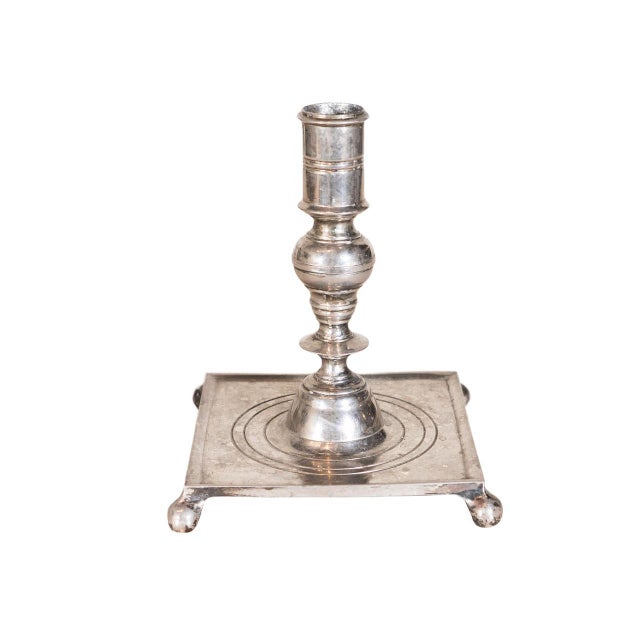 William and Mary style candlestick. Silver plated with Baluster-turned stem. Flat square base with petite bun feet.