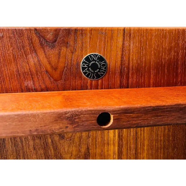 A classic side table designed by Finn Juhl having distinctive raised sides over tapered legs with removable center shelf...