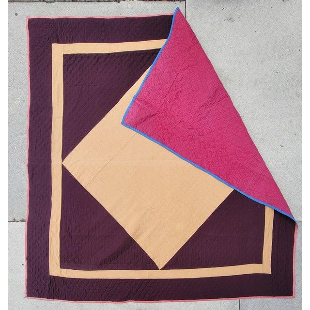 1930s hand made wool diamond in a square quilt with rare deep magenta and beige. the background is a solid pink backing....