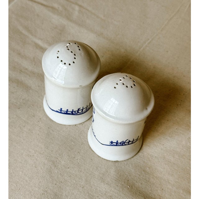 Decorated with delicate cobalt blue illustrations on a crisp white glaze, these charming ceramic salt and pepper shakers...